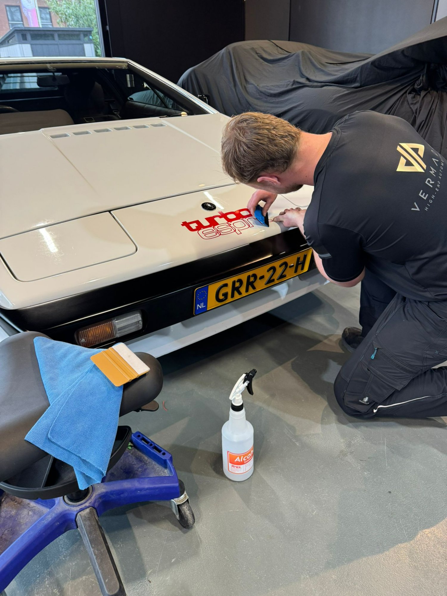 De turbo esprit sticker op de motorkap wordt aangebracht